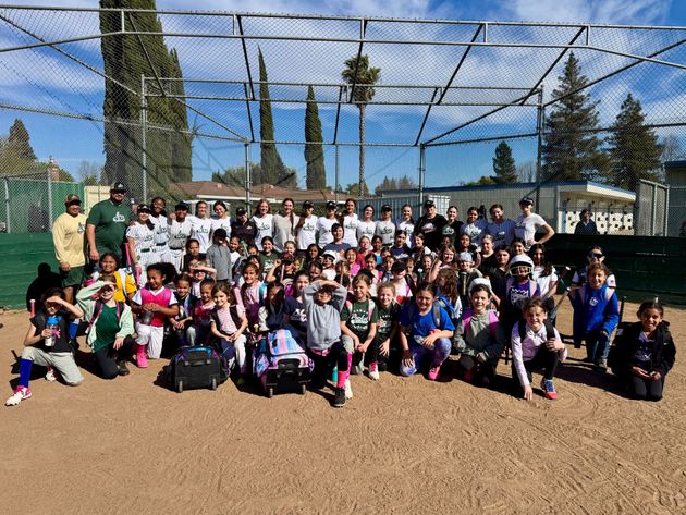 Group photo of softball players of all ages after a clinic.