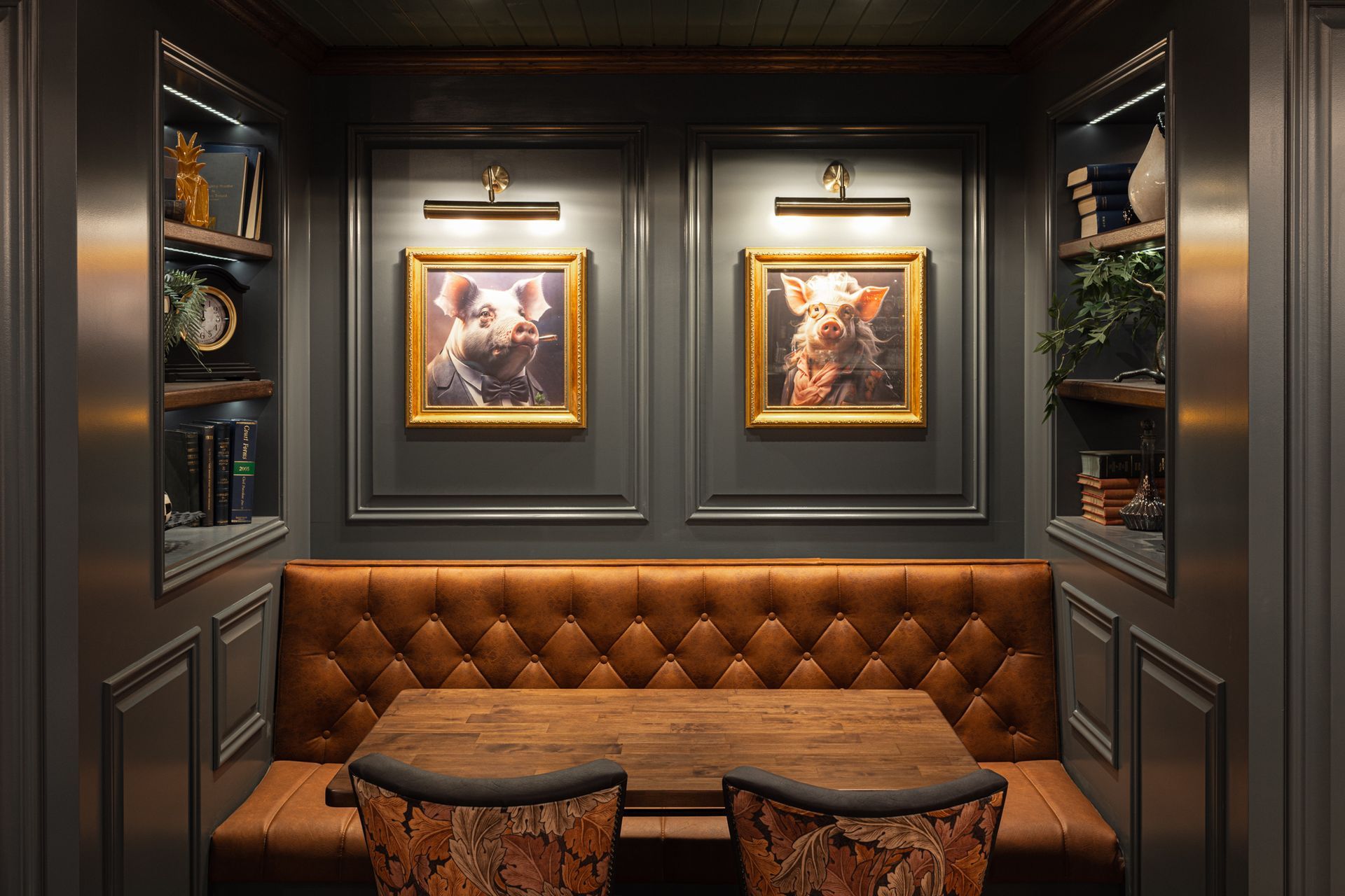 A room with a table and chairs and two paintings on the wall.