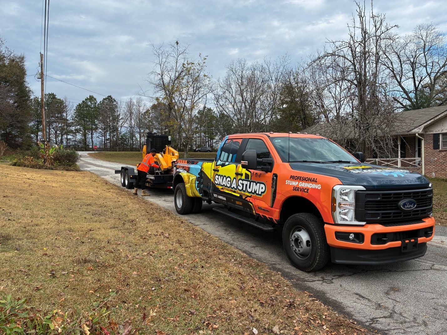 Stump grinder shredding a tree stump, creating wood chips. Yellow machine, outdoor setting.