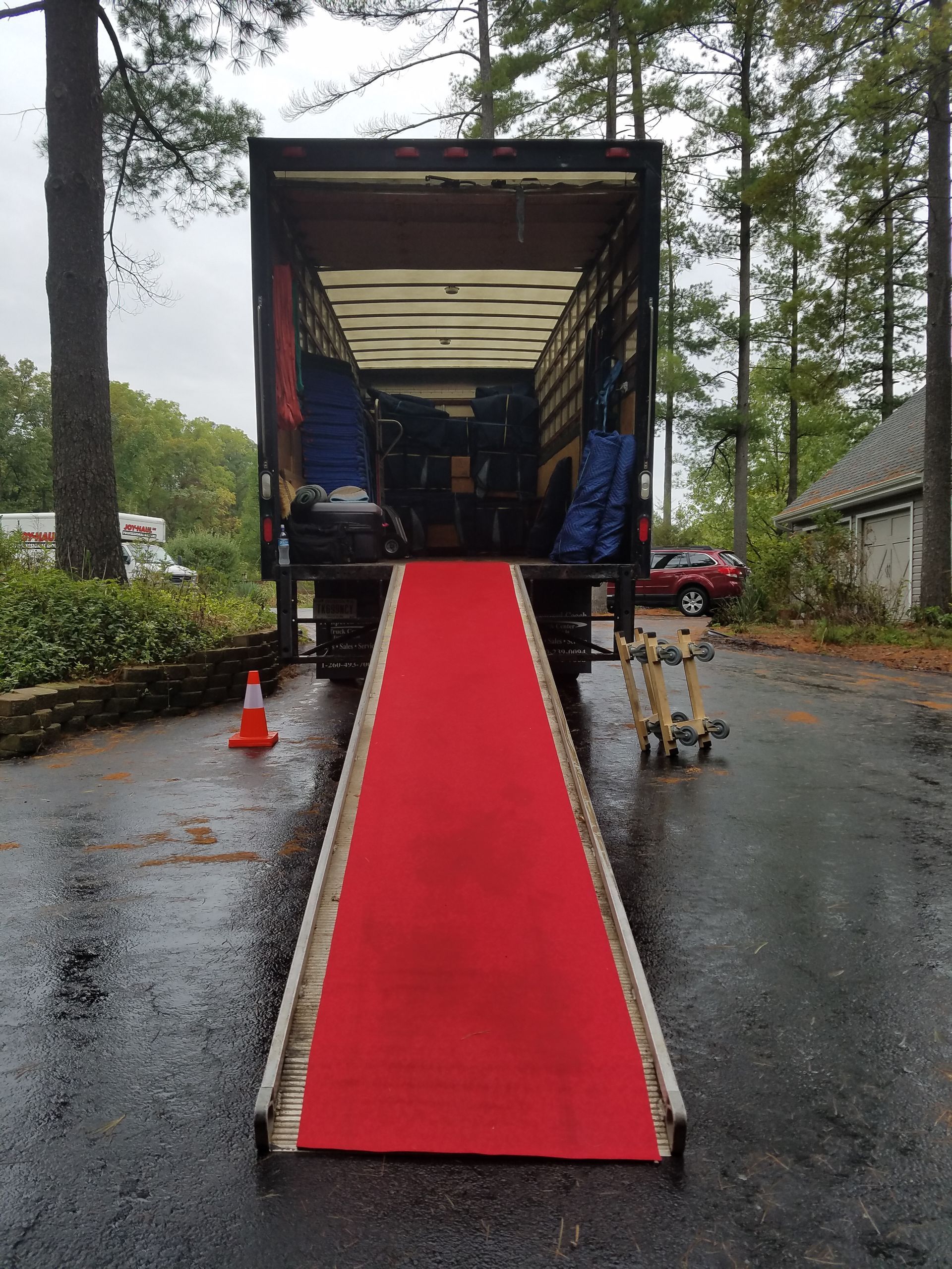 a moving truck with a red carpet leading to it