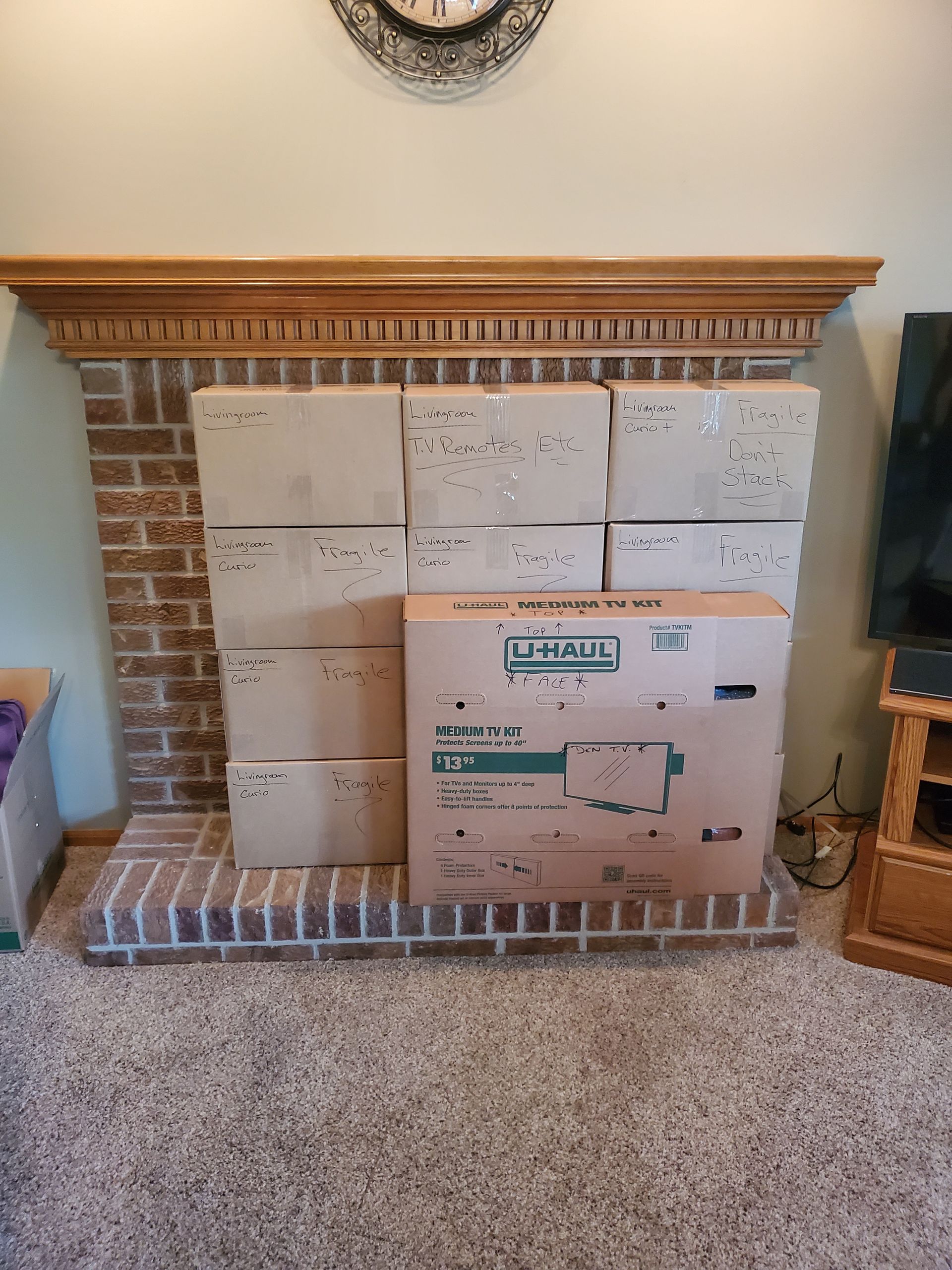 a stack of u-haul boxes on top of a brick fireplace