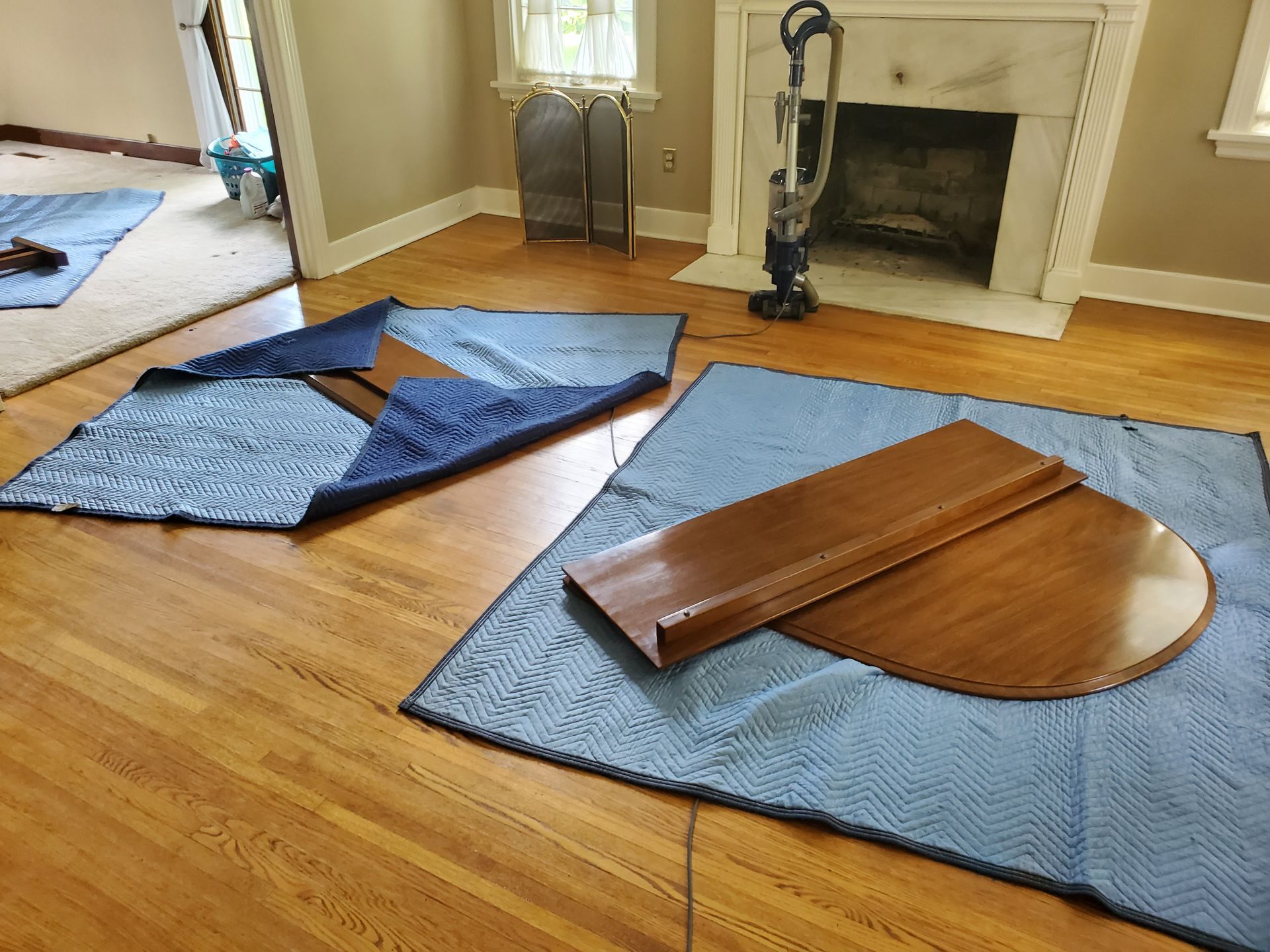 a wooden table is sitting on a blue blanket in a living room.