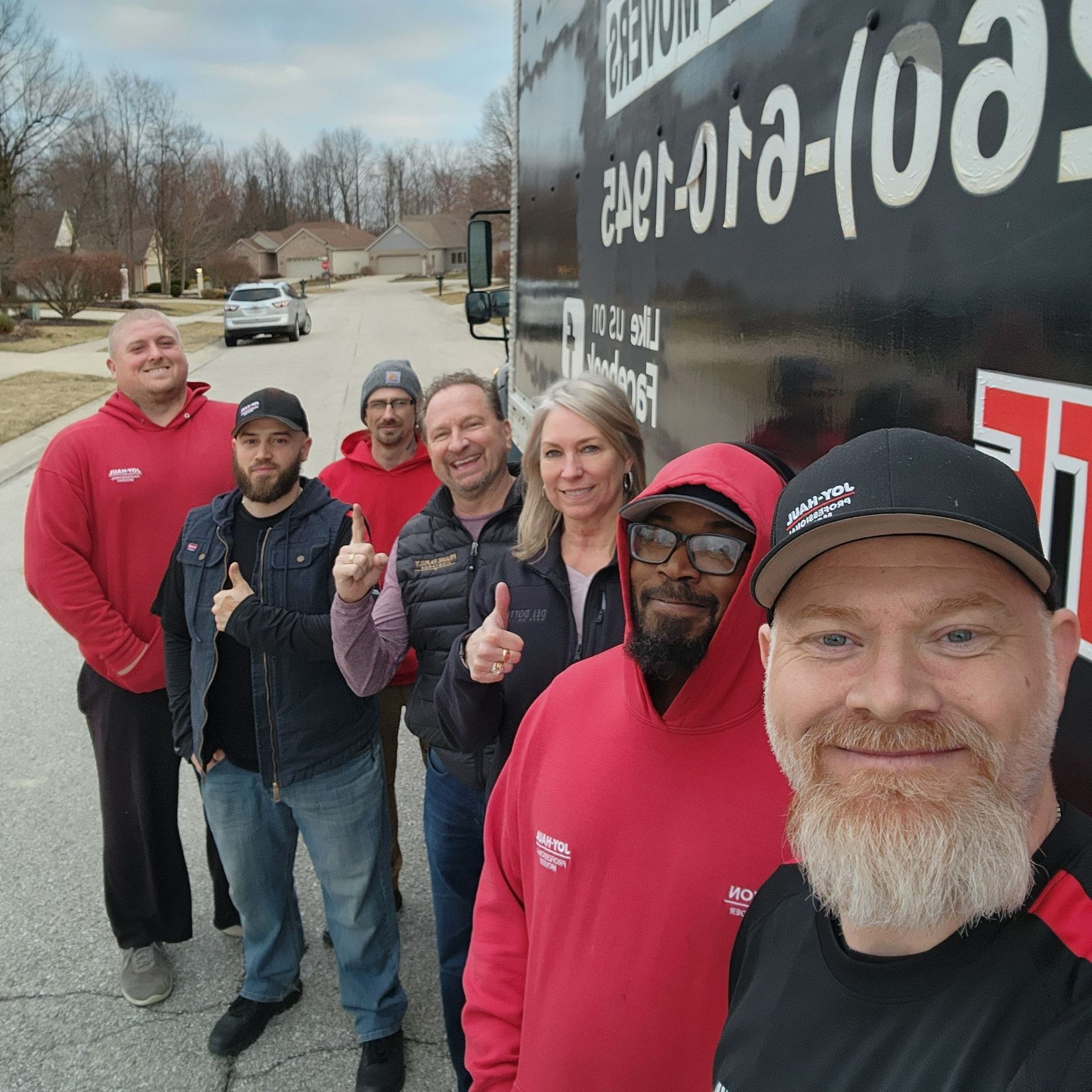 a group of people standing in front of a moving truck