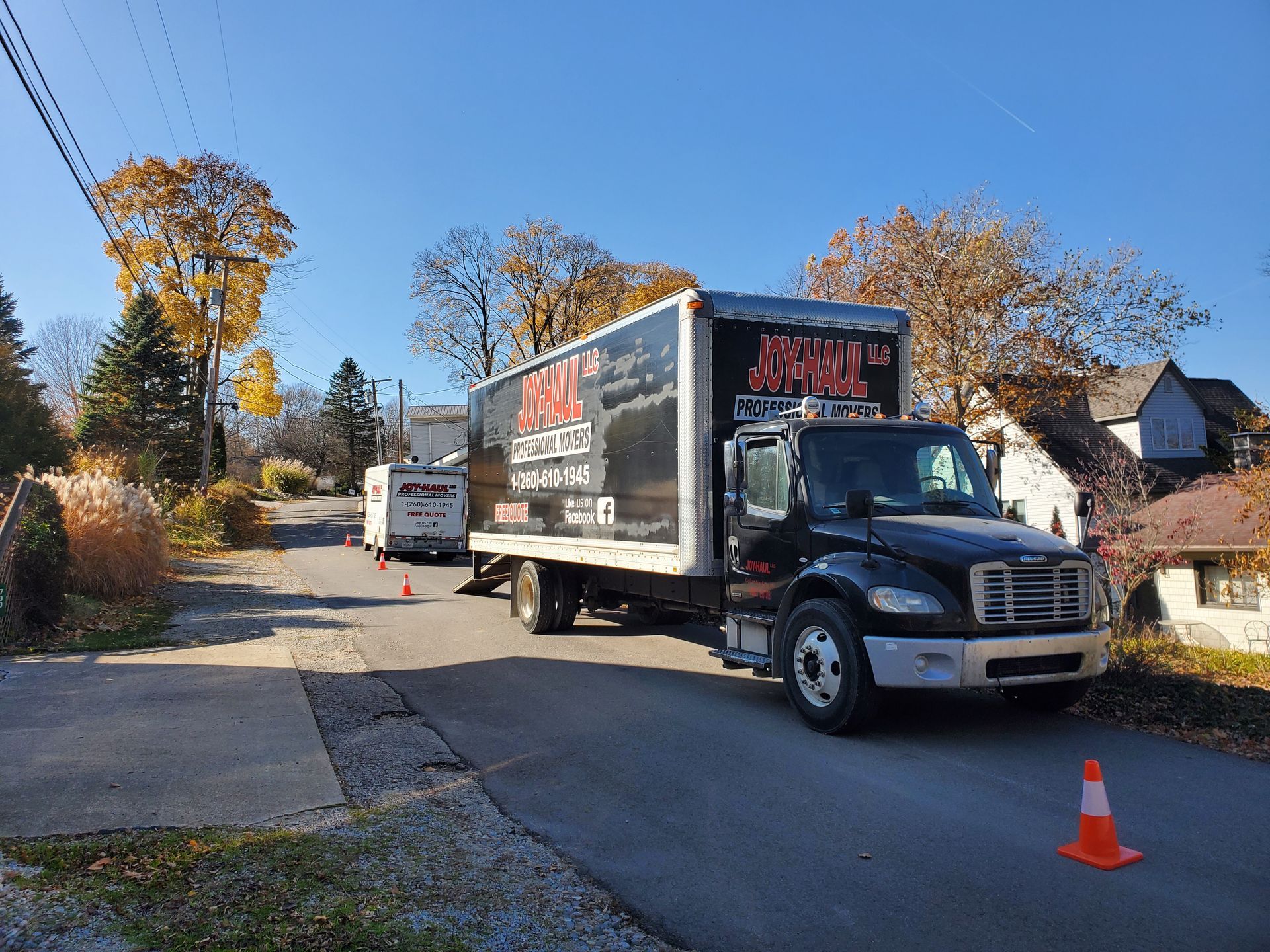 A black moving truck is parked on the side of the road.