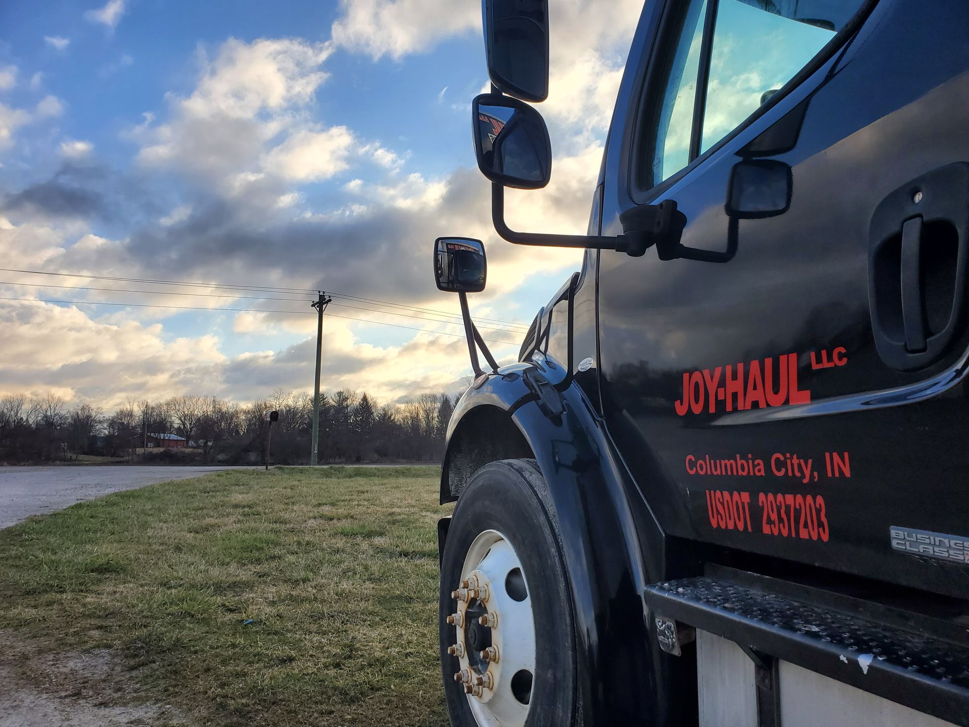 A black joyhaul truck is parked on the side of the road.