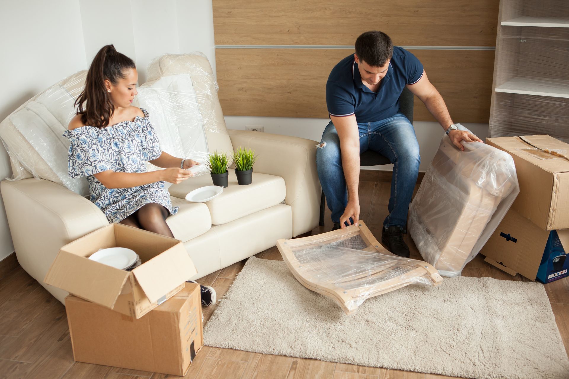 A man and a woman are sitting on a couch in a living room.