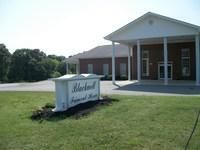 Blackwell Funeral Home with a white sign in front, building is brick.