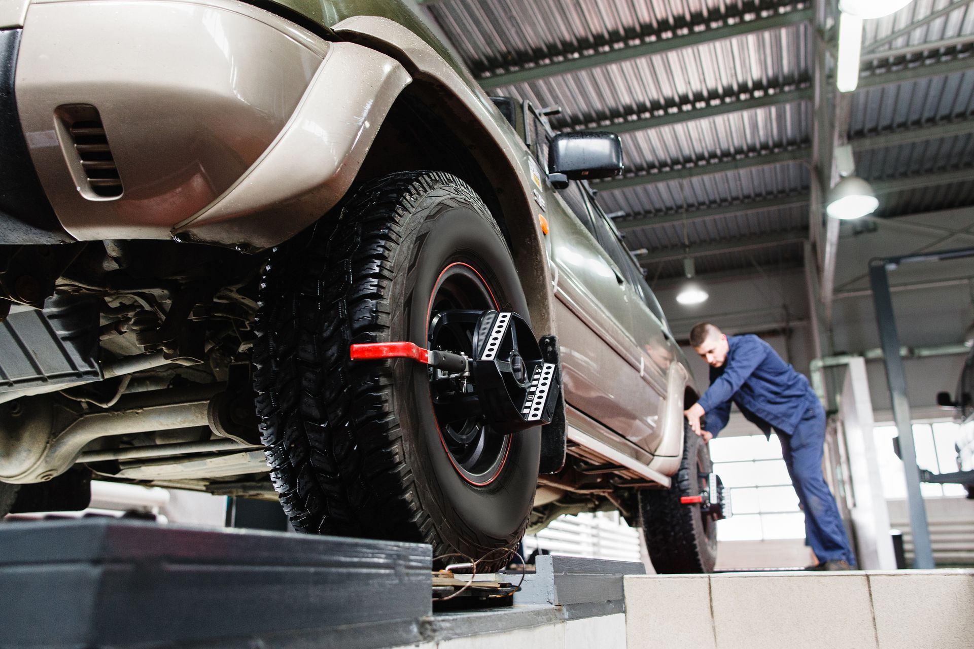 A man is adjusting the alignment of a car in a garage | Browns Automotive