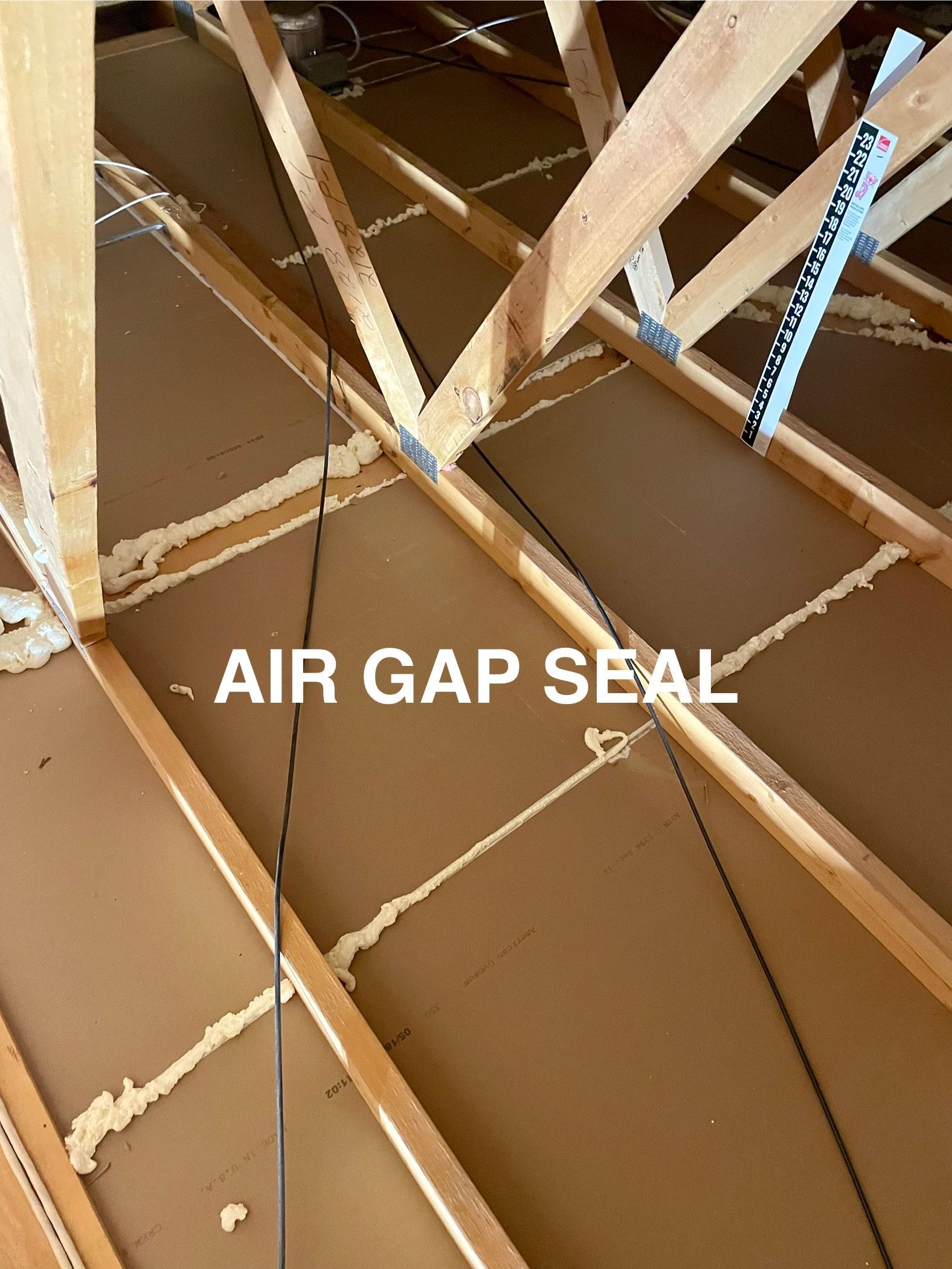 Brown insulated attic with wooden beams, sealed air gaps.