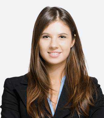 A woman with long brown hair is wearing a black jacket and a blue shirt.