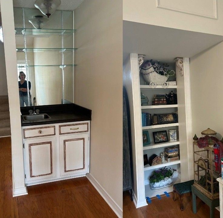 White vanity with black countertop and mirror beside built-in shelving with baskets and decor in a hallway