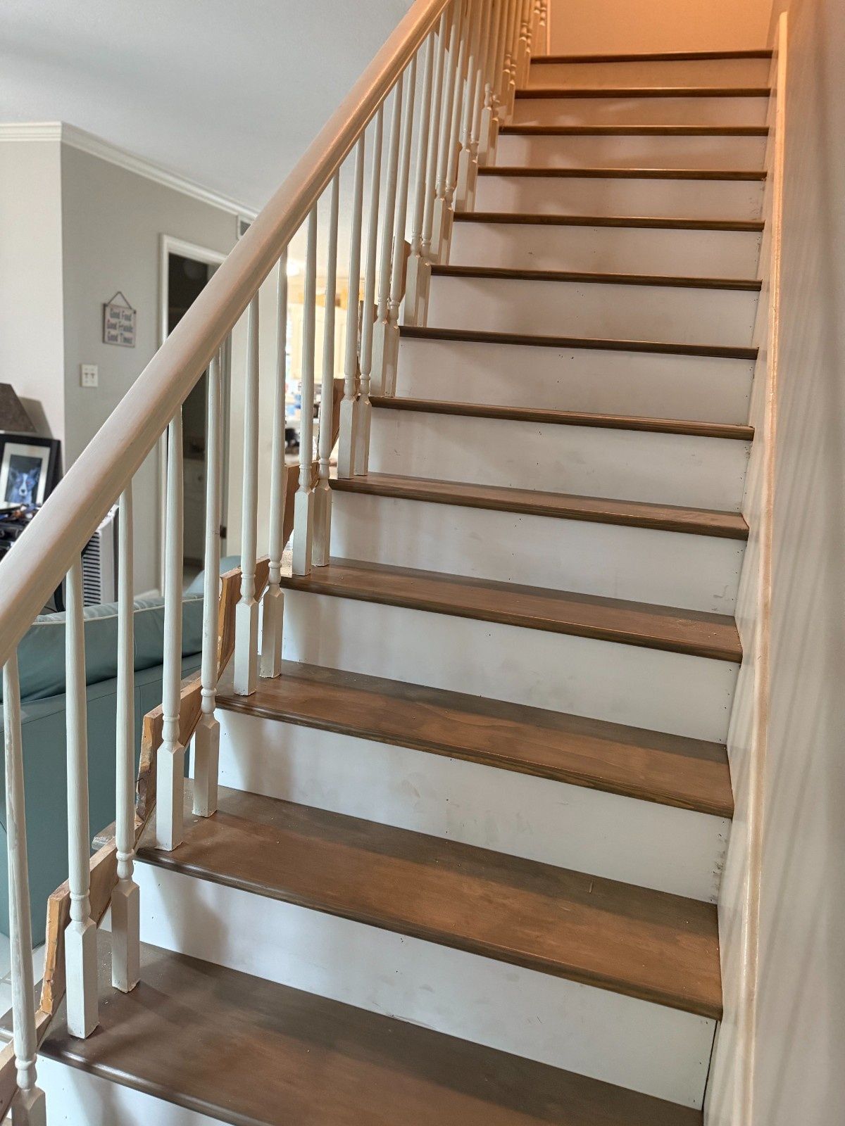 Indoor staircase with wooden steps, white railing, and beige walls in a home.