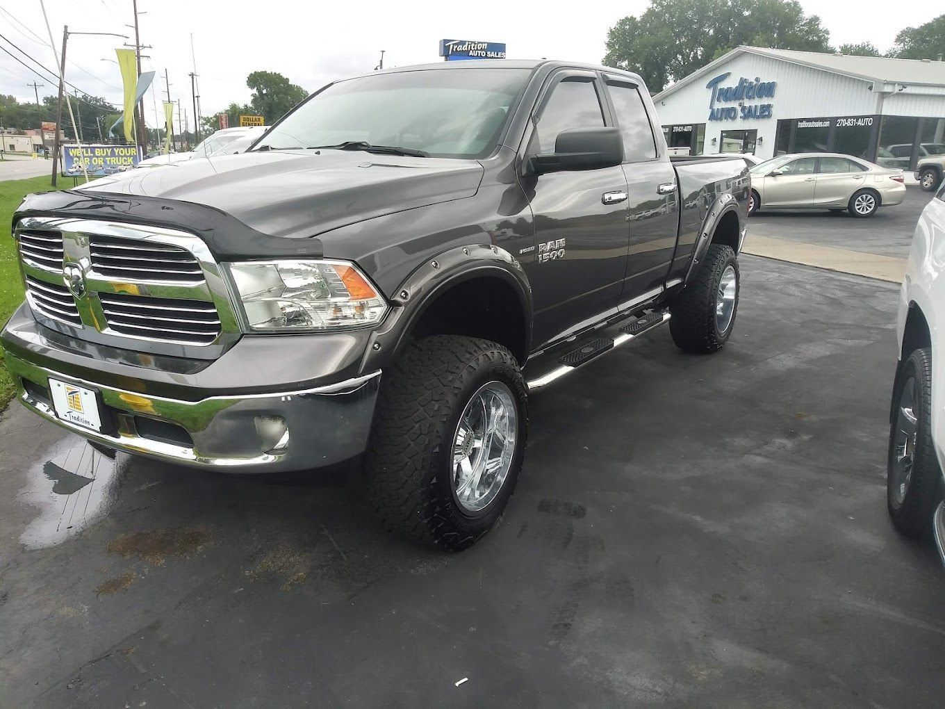 A gray dodge ram truck is parked in a parking lot.