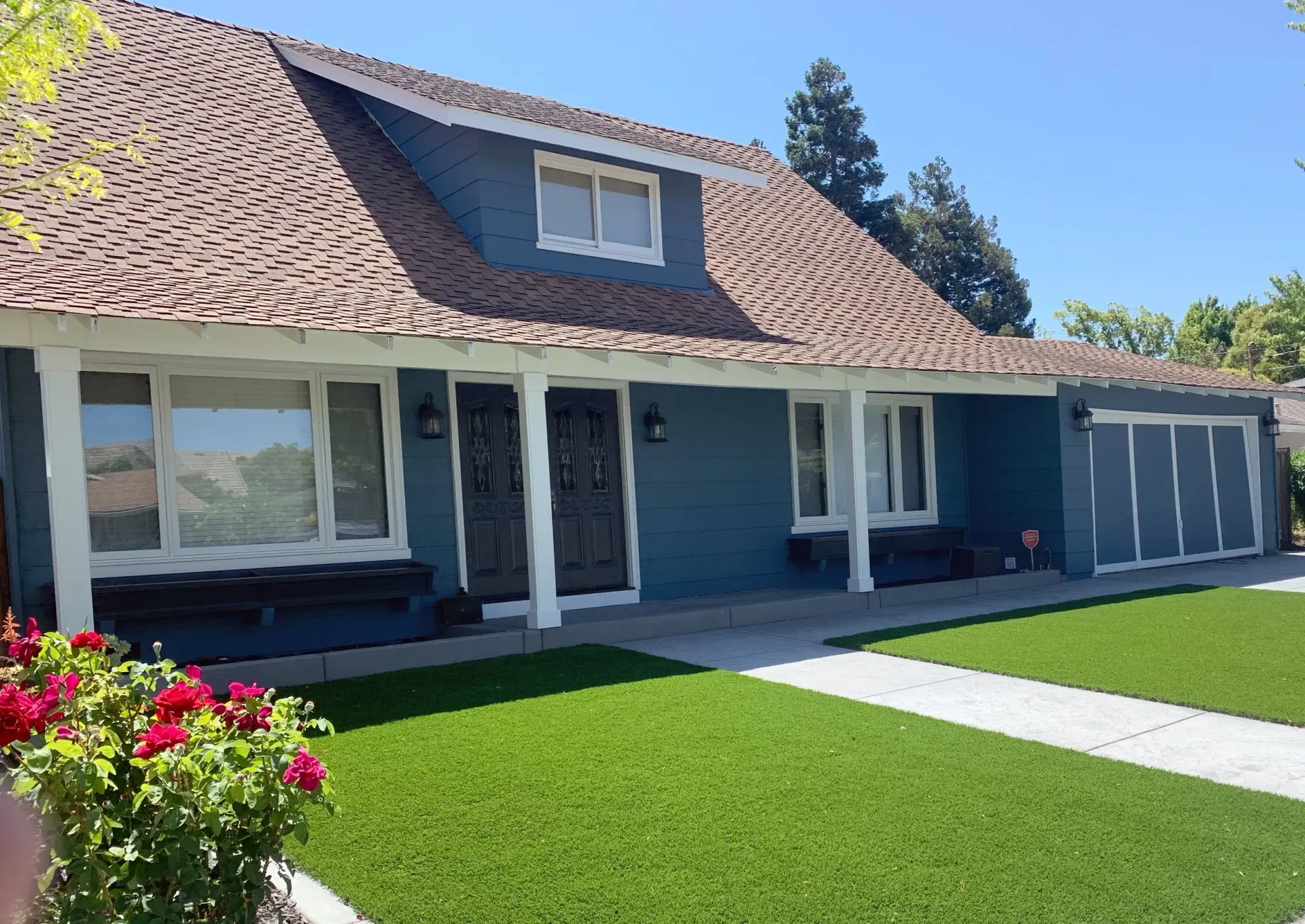 Exterior painting of blue house with brown tile roof, white trim, and green lawn on a sunny day.