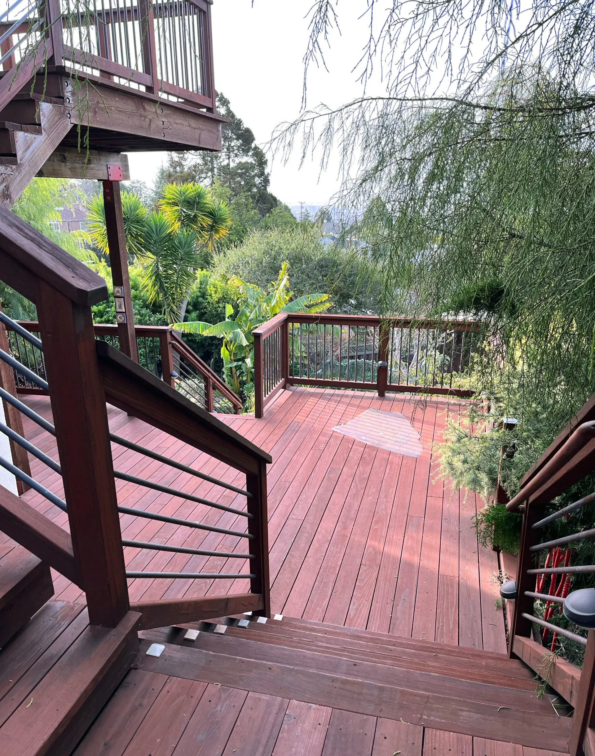 Painting of wooden deck with stairs, railing, and view of trees.