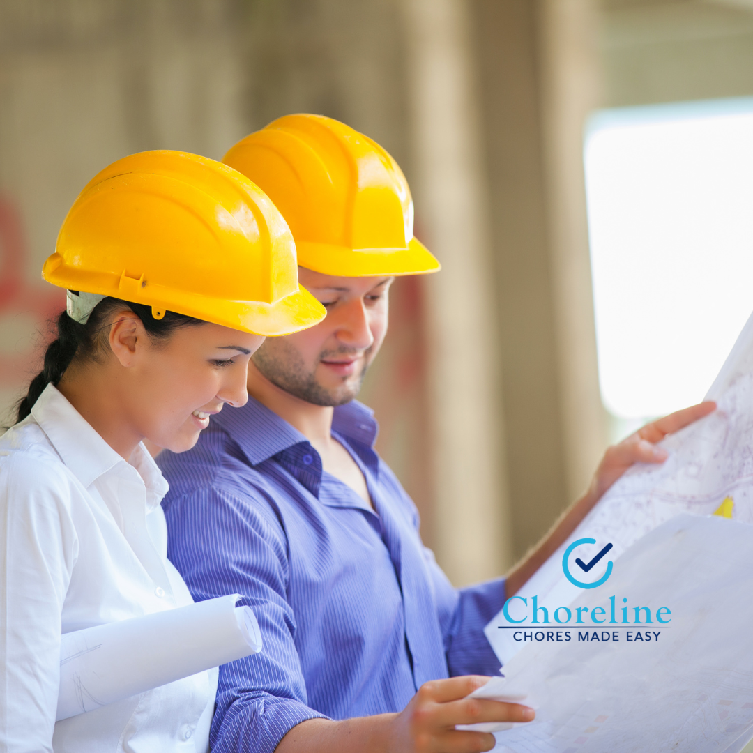 a man and a woman wearing hard hats are looking at a blueprint