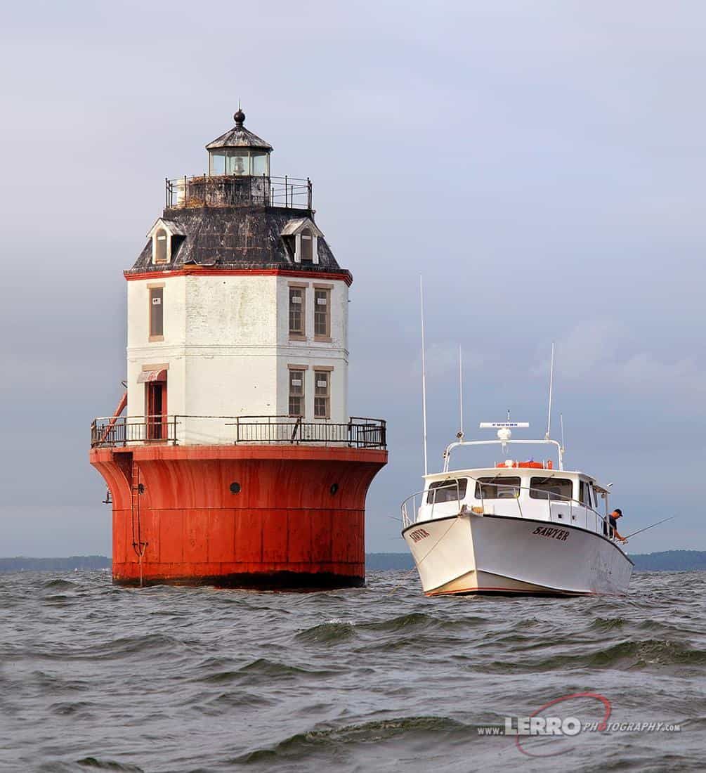 Man fishing off of a boat next to the Baltimore Light - used with permission.