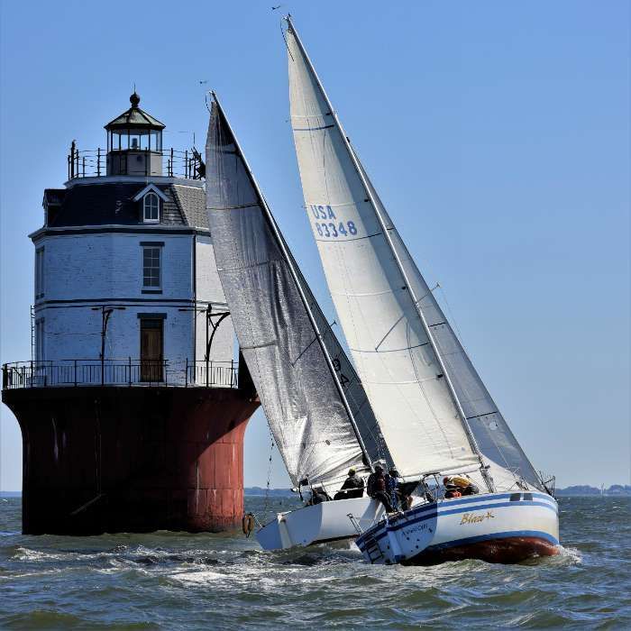 Photo of sailboat going by the lighthouse by Will Keyworth with permission by SpinSheet magazine
