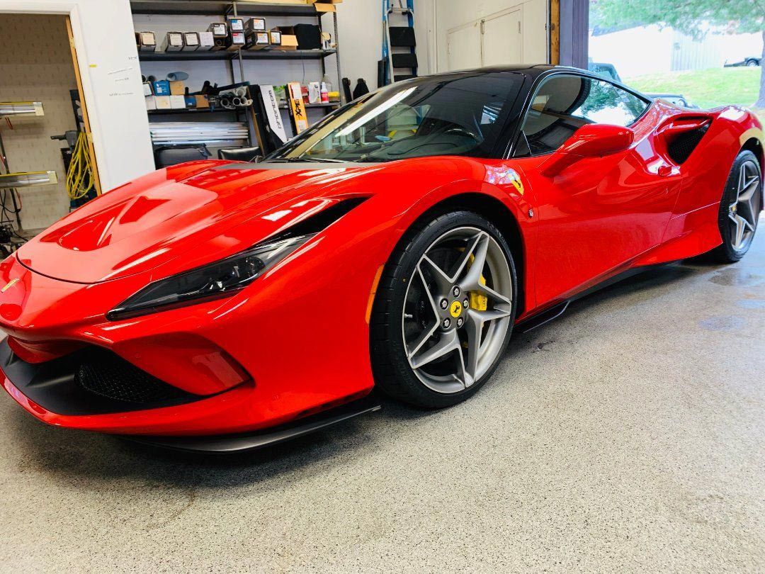 Red Ferrari sports car parked inside a garage.