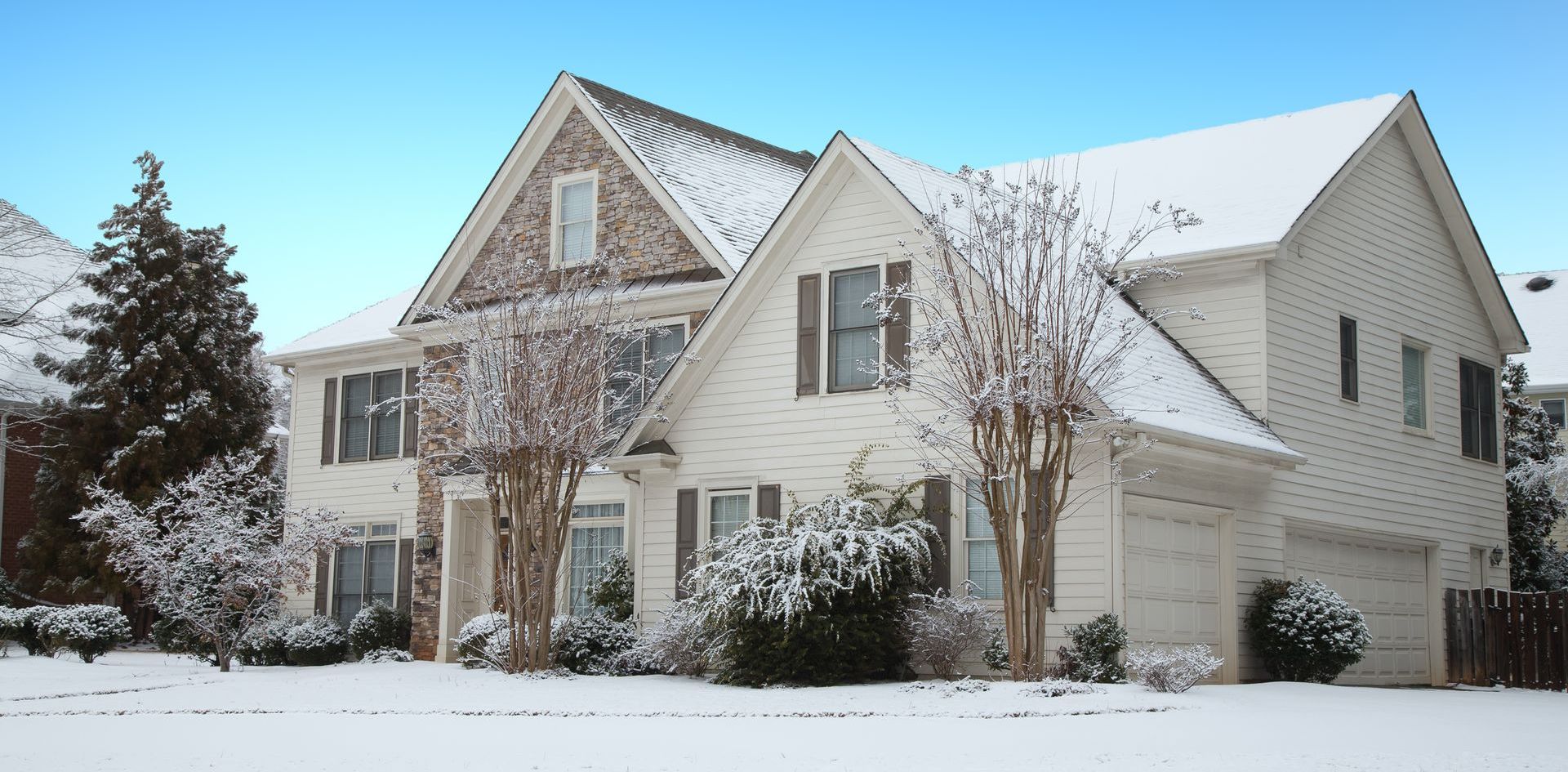 Une grande maison blanche est recouverte de neige