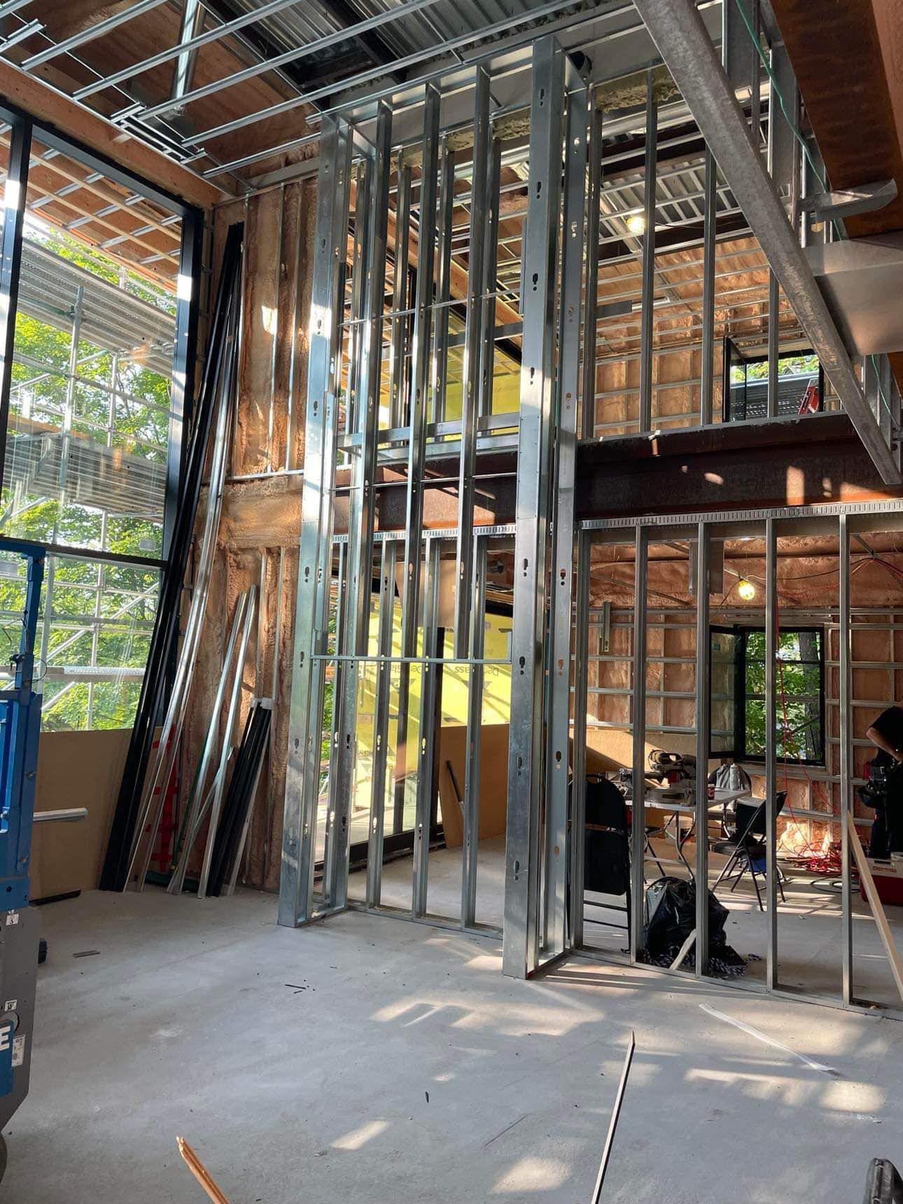 L'intérieur d'un bâtiment en construction avec beaucoup de charpentes métalliques.