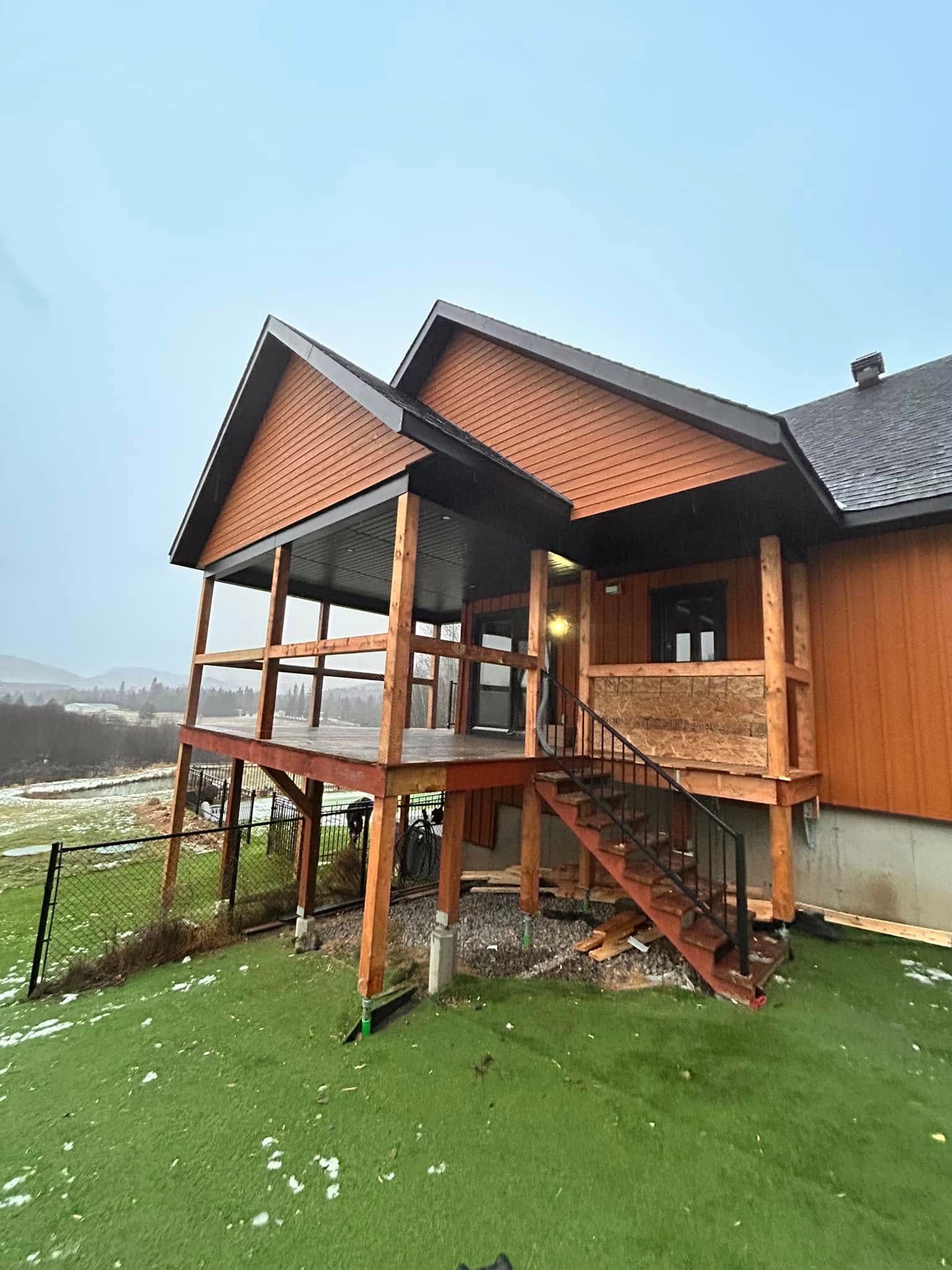 Une grande maison en bois avec un grand porche et des escaliers.