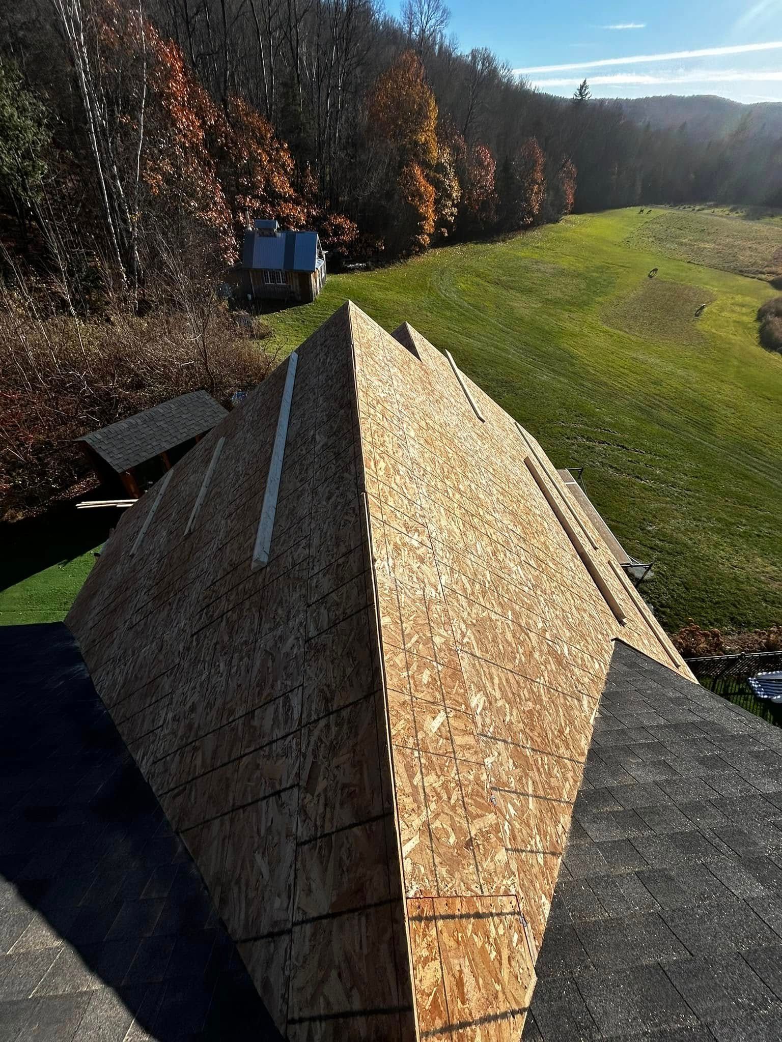Une grande pyramide en bois est posée au sommet d'un toit.