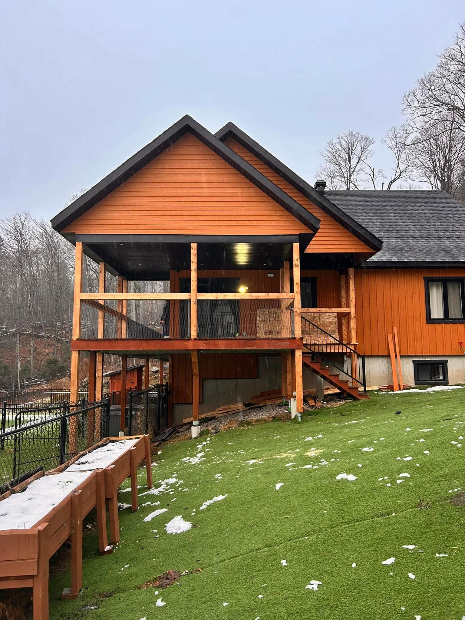 Une grande maison en bois avec un grand porche et des escaliers.