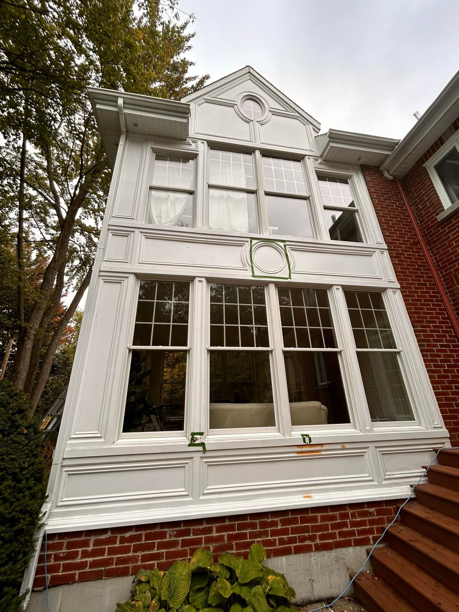Une grande maison blanche avec beaucoup de fenêtres et d'escaliers.