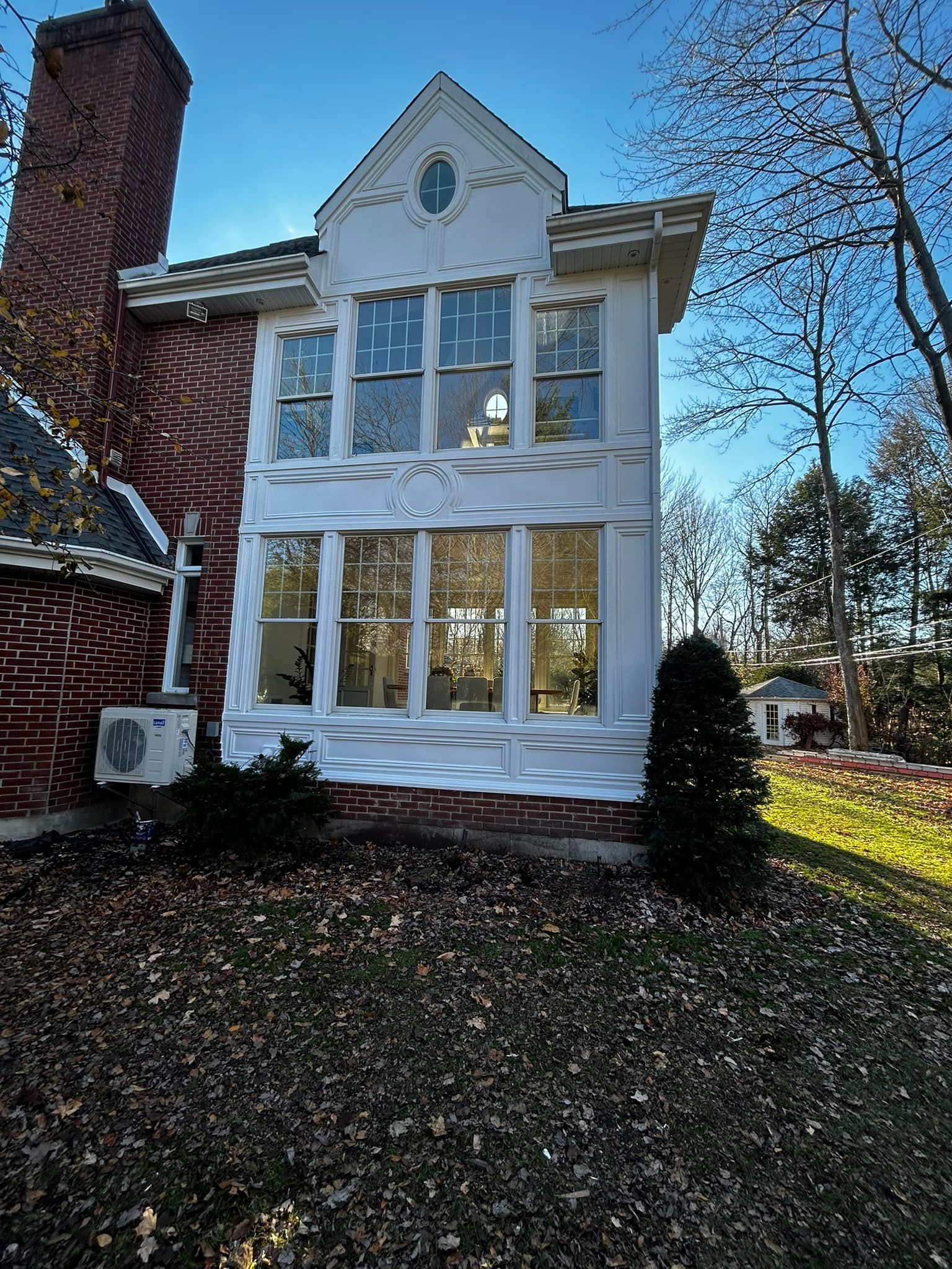 Une maison en briques avec beaucoup de fenêtres et une cheminée.