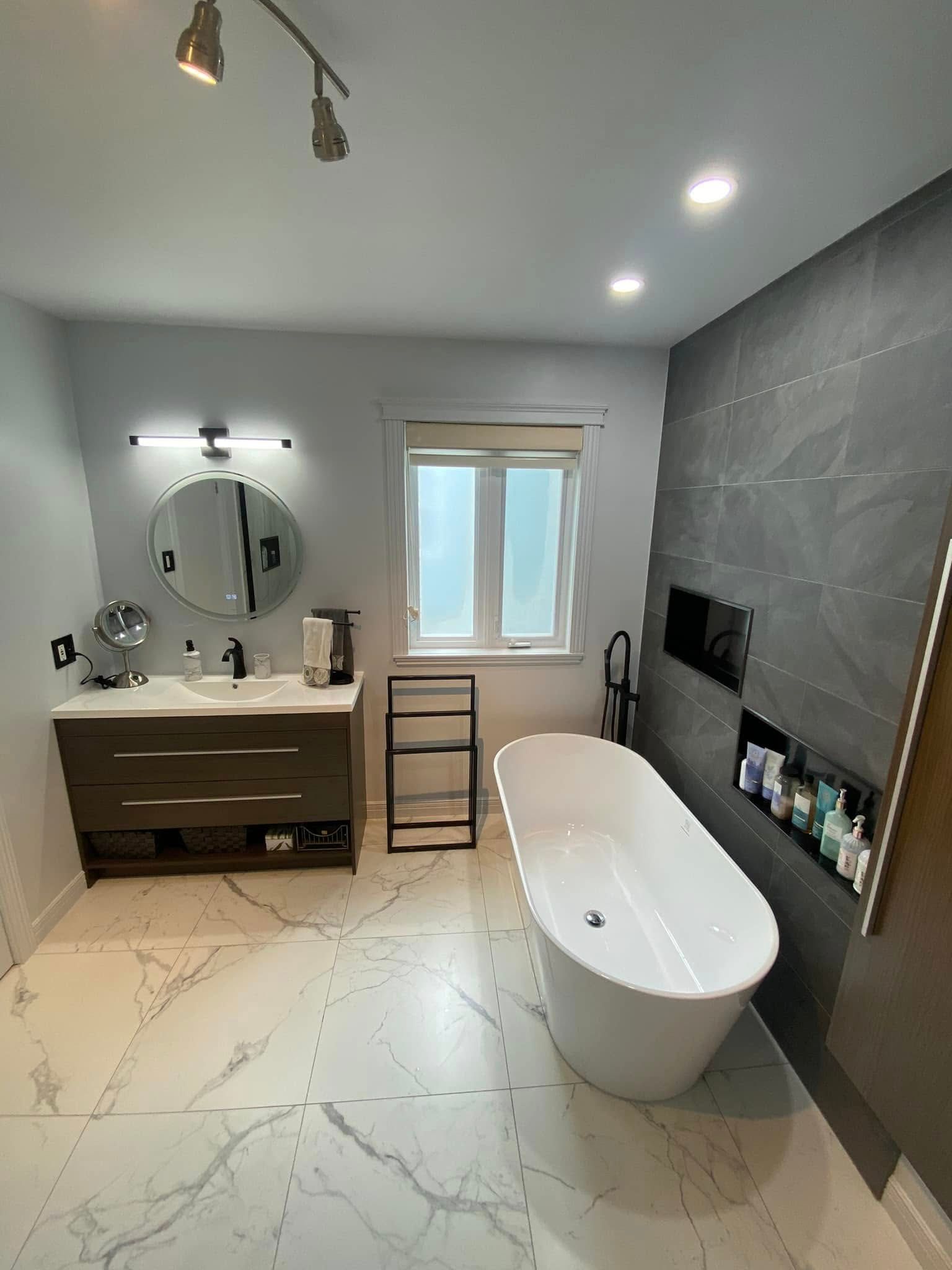 Une salle de bain avec baignoire, lavabo, miroir et fenêtre.