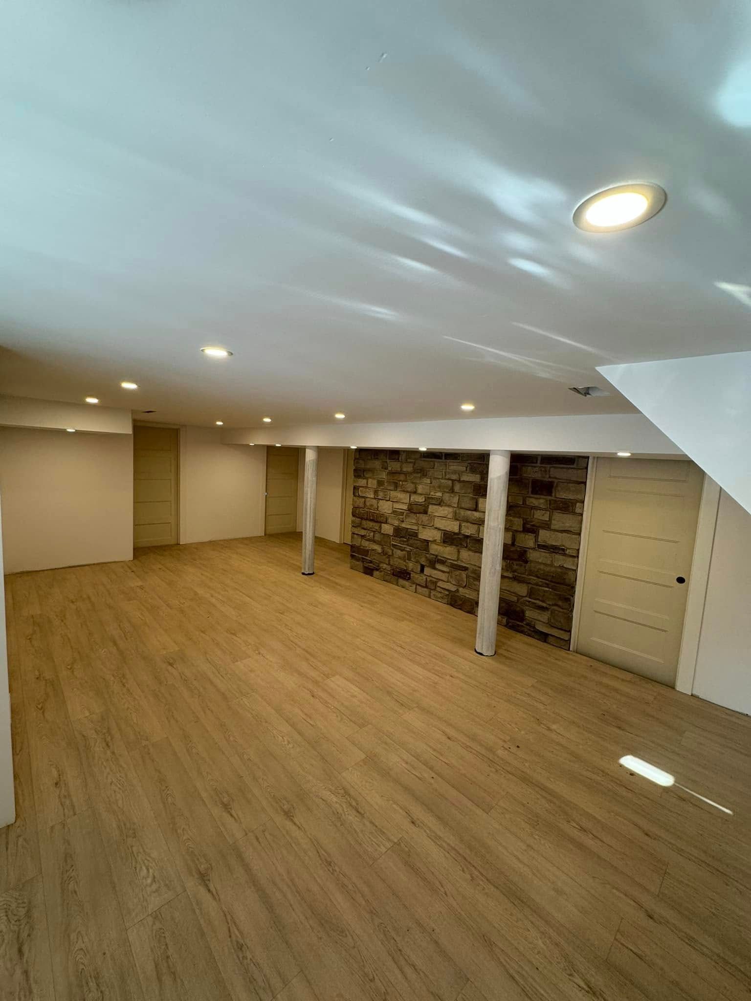 Un sous-sol vide avec planchers de bois franc et un mur en pierre.