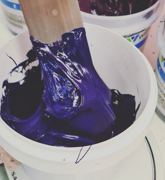 man mixing color in a bucket