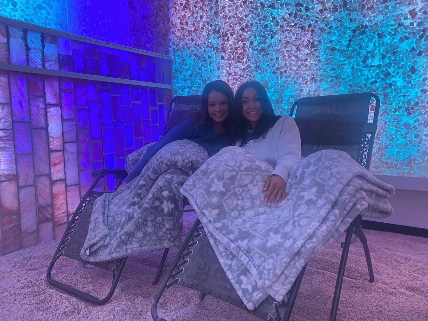 Tranquil salt therapy room with glowing Himalayan salt walls, soft lighting, and zero-gravity chairs for relaxation