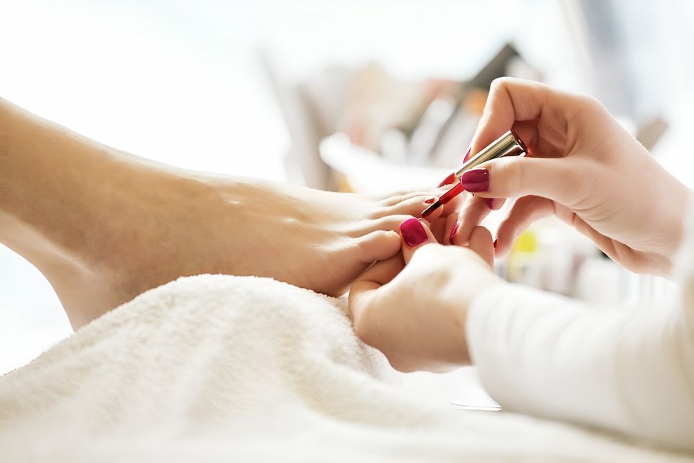 A Woman Is Getting Her Nails Painted At A Nail Salon — Bundy Nail & Spa in Avoca, QLD