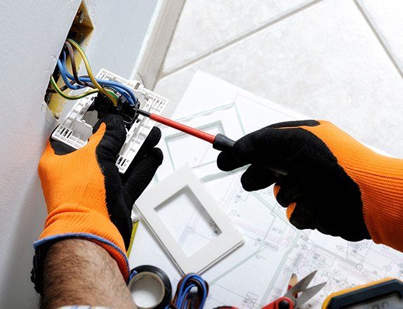 Electrician Working Safely on Switches and Sockets — Clairsville, OH — Bryan Electric Inc.