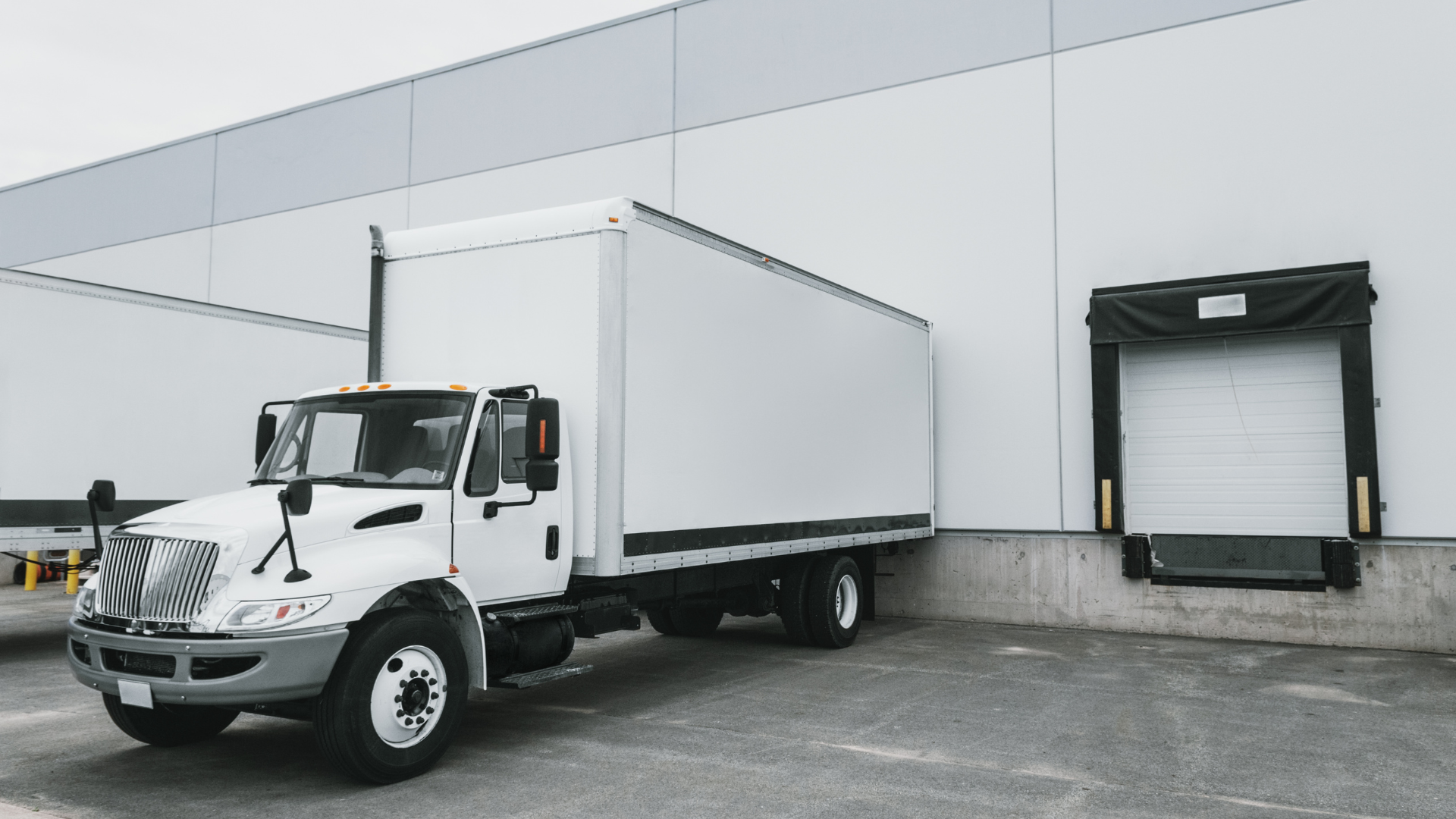 A white truck is parked in front of a building.