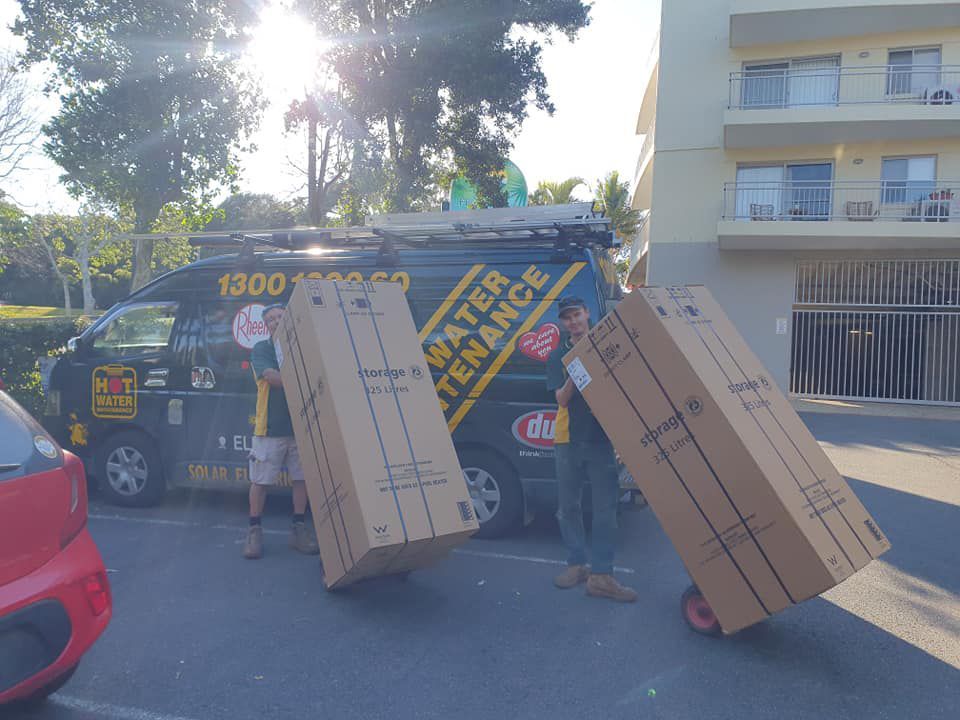 Team holding a box — Hot Water Systems in Port Macquarie, NSW