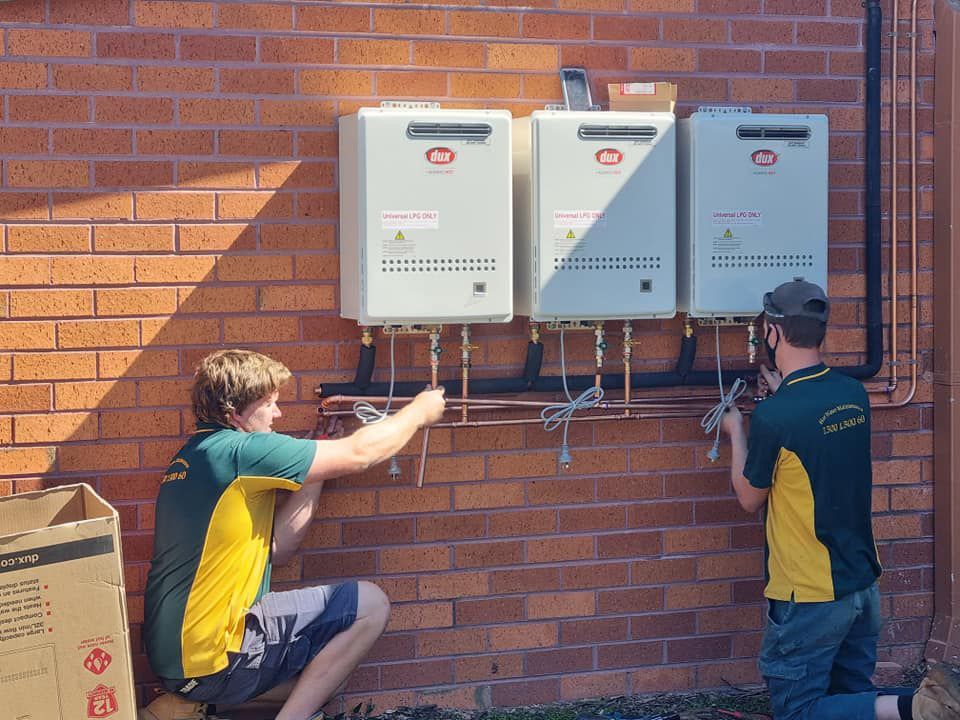 Two technician fixing water heater boiler — Hot Water Systems in Port Macquarie NSW