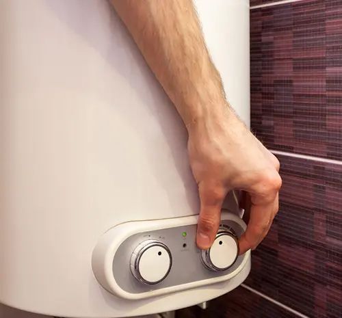 Technician turning on the water heater — Hot Water Systems in Laurieton, NSW