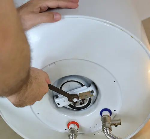 Man's hands unscrewing a screw-nut on a water heater — Hot Water Systems in South West Rocks, NSW