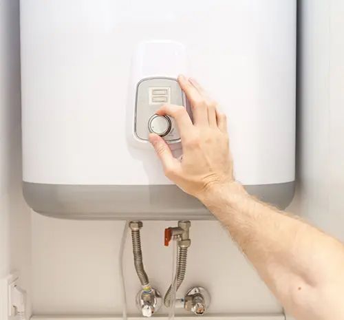 Man hands setting the temperature of water in Electric Boiler — Hot Water Systems in South West Rocks, NSW