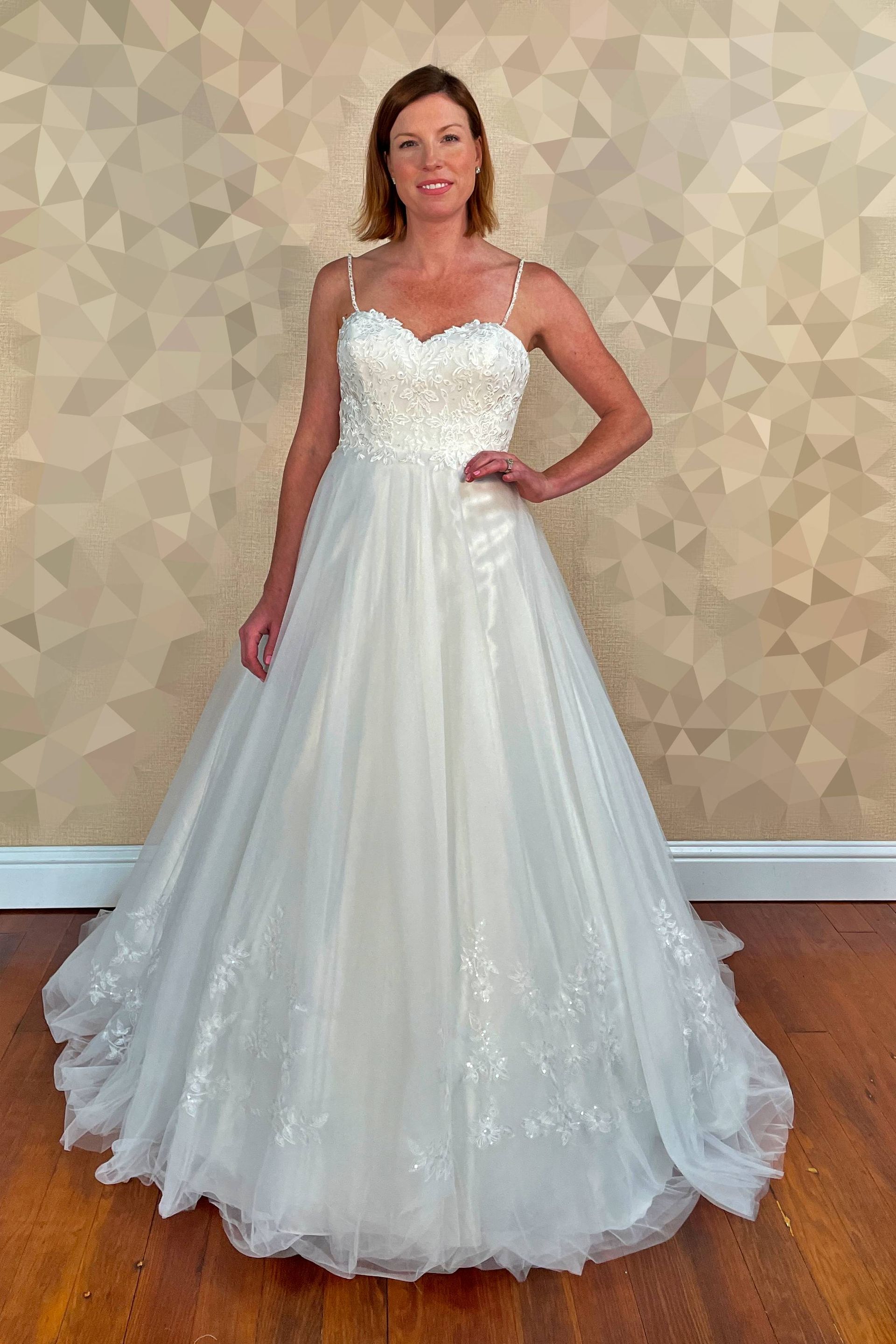 Woman in white wedding dress, smiling, indoors.