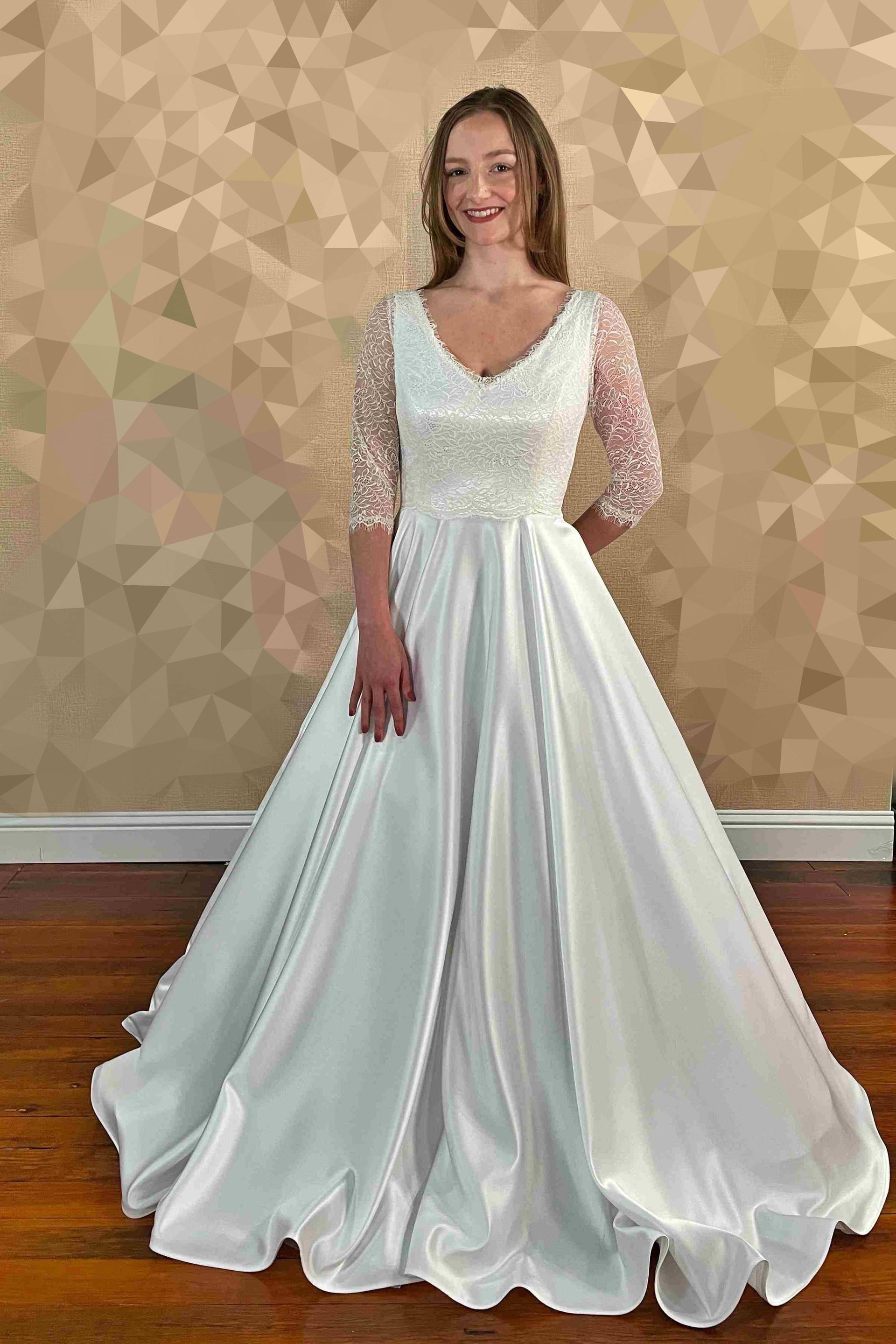 Woman in a white wedding gown with beaded bodice and flowing skirt.