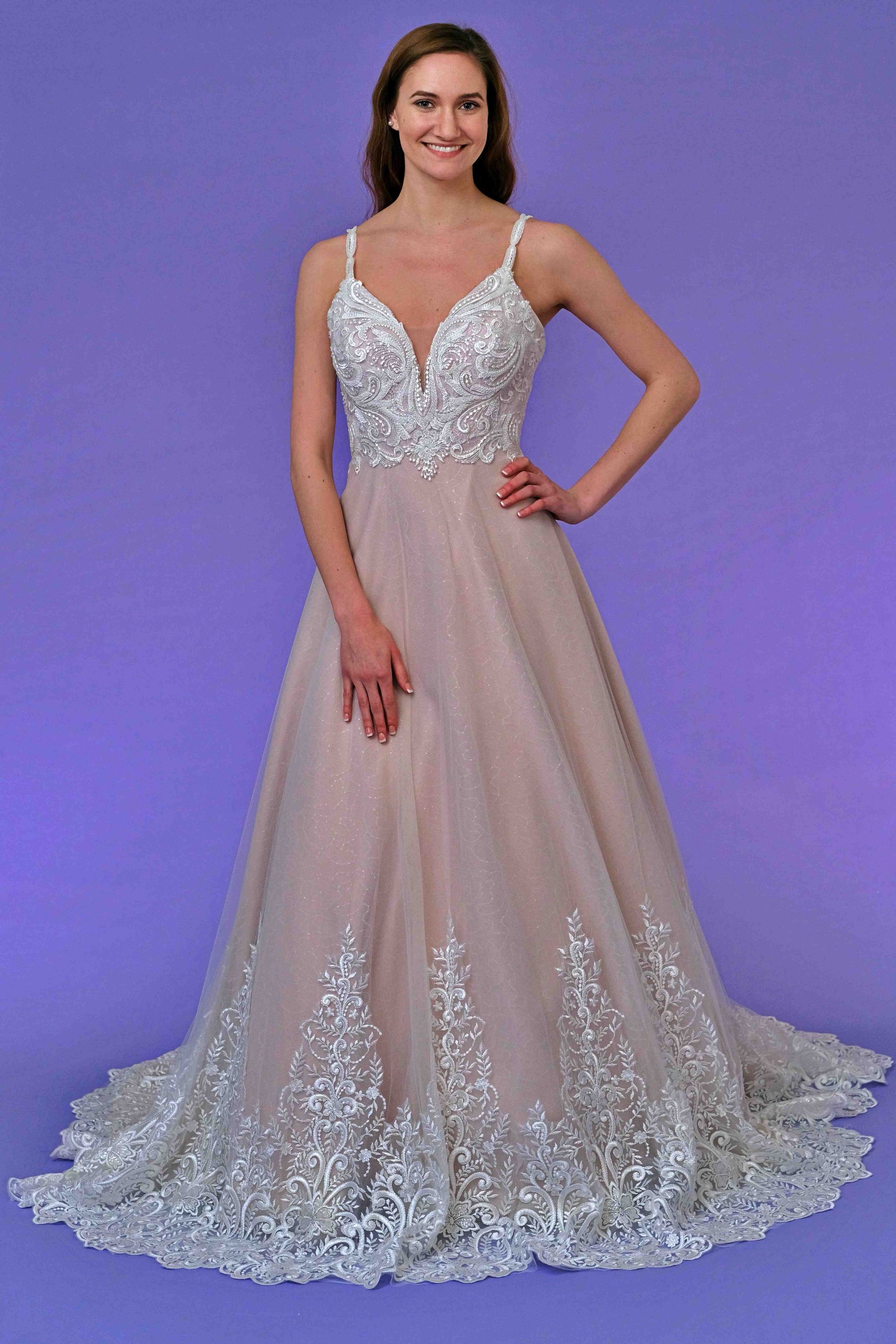 Woman in formal gown with silver bodice and trim, pink skirt, on purple background.