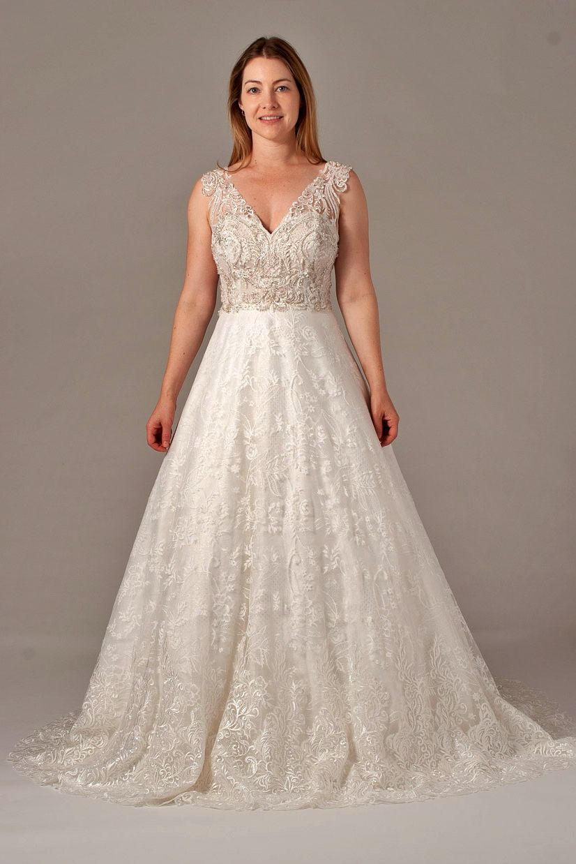 Woman in a sparkly white wedding dress with a V-neckline and embellished bodice.