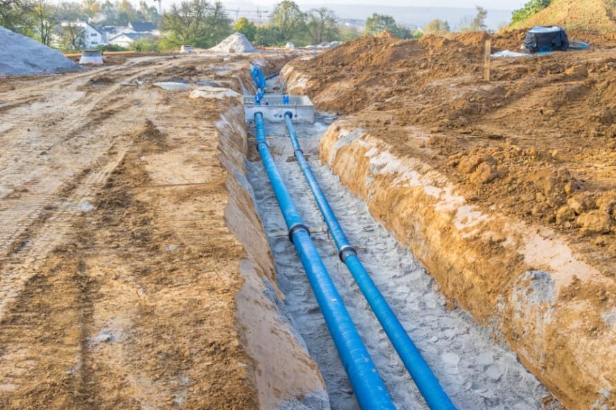 Blue Pipes Laid in a Trench at a Construction Site — Rhino Excavator & Bobcat Hire in Trinity Beach, QLD