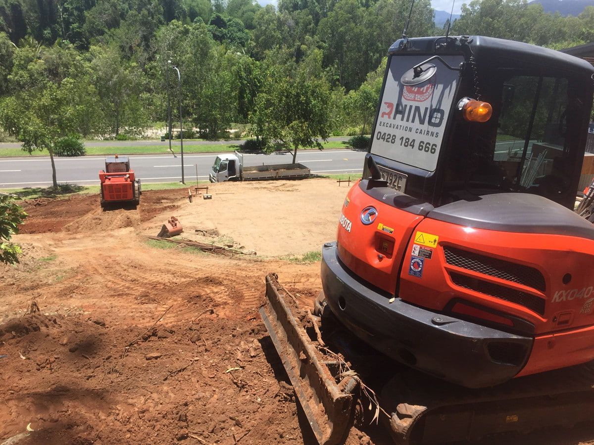 Orange Excavator and Small Red Loader on a Dirt Work Site — Rhino Excavator & Bobcat Hire in Trinity Beach, QLD