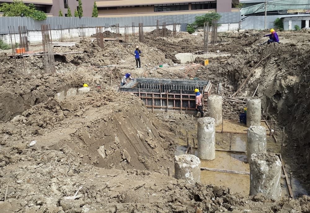 Construction Site With Workers, Dirt Mounds, Concrete Pillars — Rhino Excavator & Bobcat Hire in Trinity Beach, QLD
