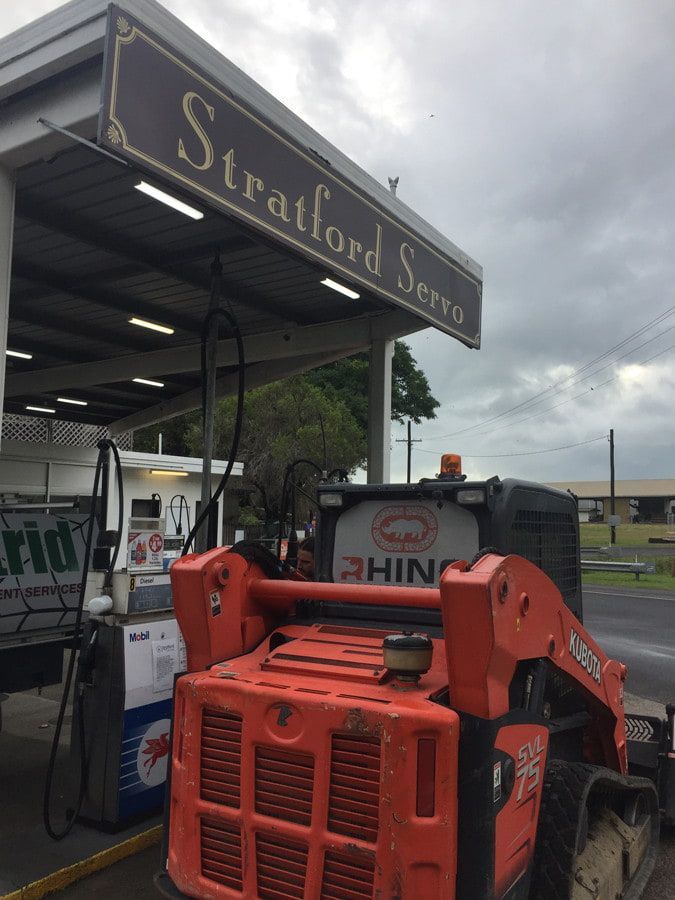 Orange Skid Steer Loader at the Stratford Servo Gas Station — Rhino Excavator & Bobcat Hire in Trinity Beach, QLD